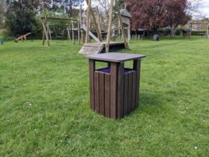 A new brown bin next to playground